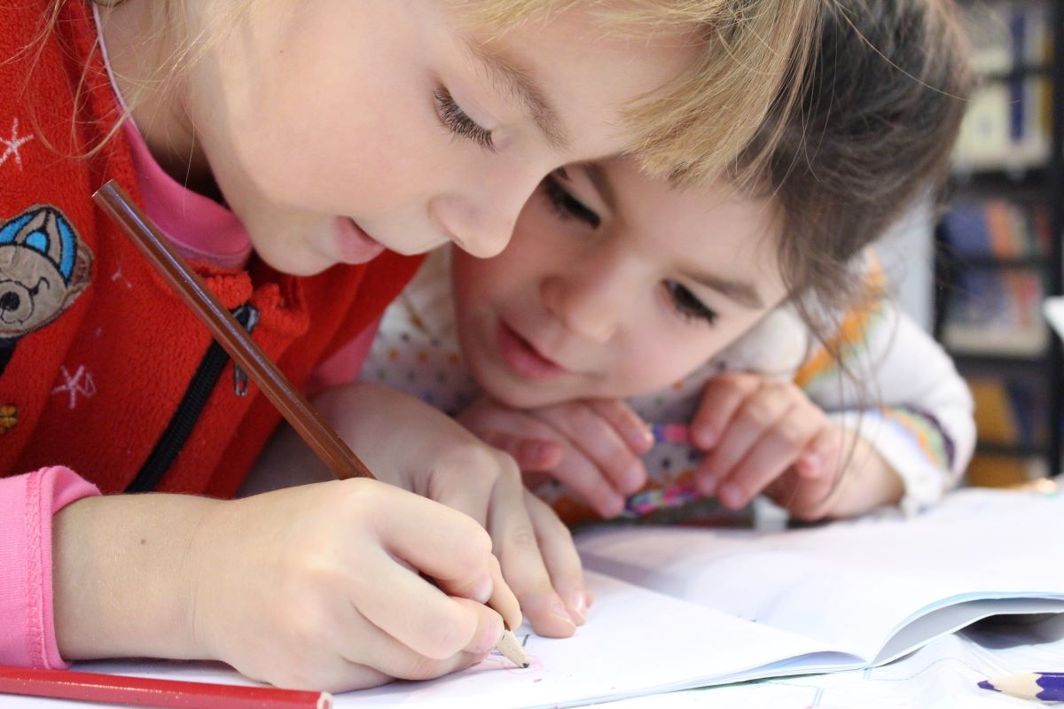 Two children are writing together