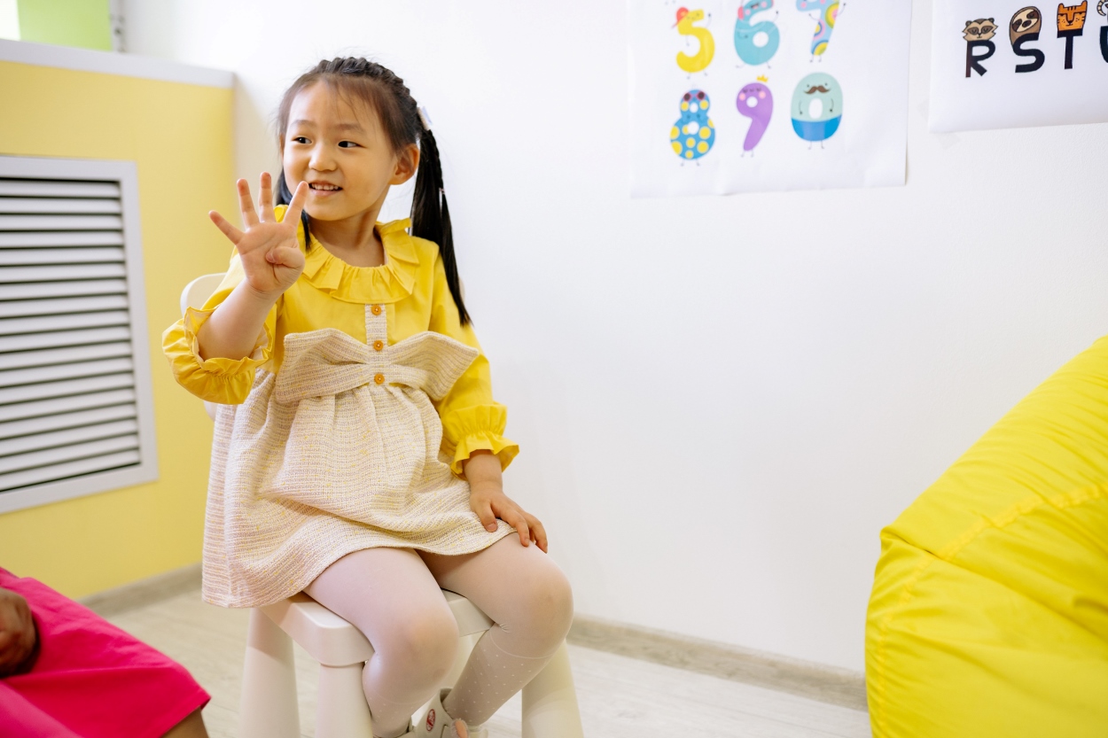 A little girl is counting on her fingers 